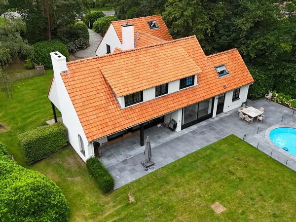 Luchtbeeld van een woning met volledig geschilderde witte gevel